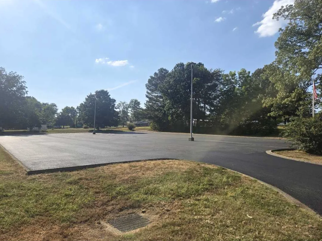 Parking lot paving on a small lot with light poles and a curbed edge