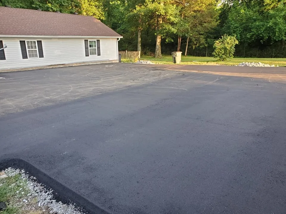 Freshly paved lot beside a white building, ready for parking lot striping