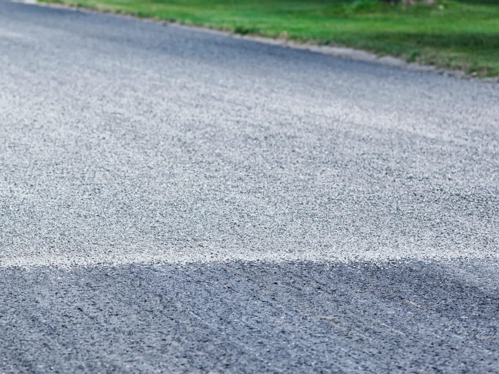 Close view of a finished tar and chip surface with stone chips over asphalt